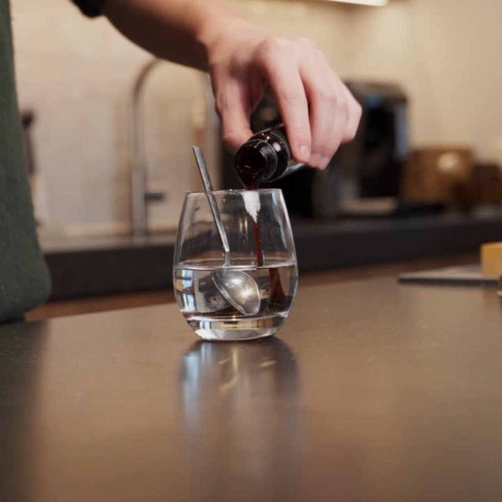 Hand pouring liquid into glass